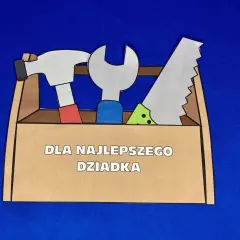 Laurka dla najlepszego dziadka w kształcie skrzynki z narzędziami: młotek, klucz i piła.