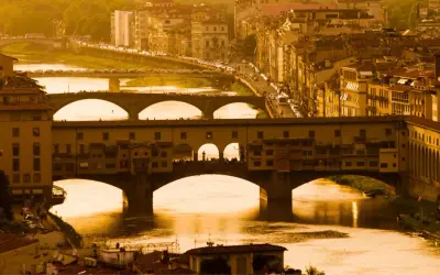 Florencja 18 maja. Złote światło zalewa Ponte Vecchio i rzekę Arno, tworząc malowniczy widok miasta.