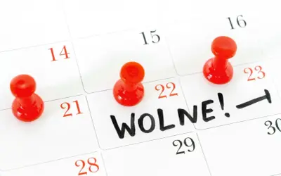 Kalendarz z zaznaczonym dniem "Wolne!" i czerwonymi pinezkami. Takie są święta w maju – czas wolny od pracy.