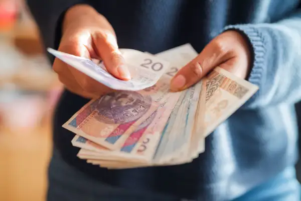 Dłonie liczą banknoty, w tym 20 zł i 100 zł. W sumie to już ponad 500 zł!